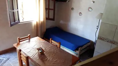 a small room with a blue bed and a table at Cabañas Kehuen in Villa Amancay