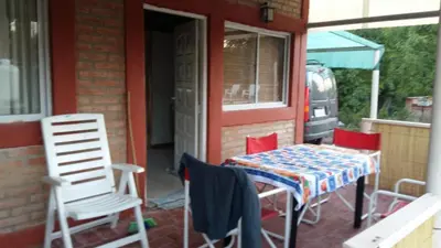 a table and chairs on the porch of a house at Cabañas Kehuen in Villa Amancay