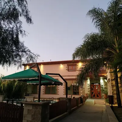 a building with a table and a green umbrella at Hotel Torres del Sol in Merlo