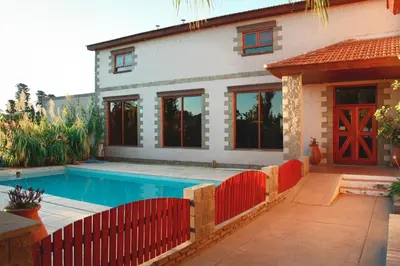 a house with a swimming pool in front of a house at Hotel Torres del Sol in Merlo
