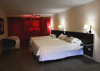 a hotel room with two beds and a red curtain at Hotel Torres del Sol in Merlo