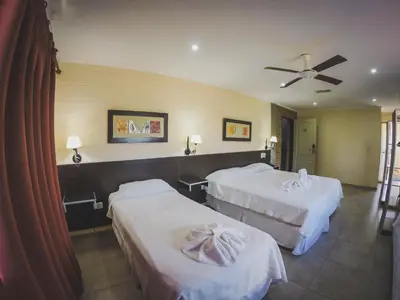 a hotel room with two beds and a ceiling fan at Hotel Torres del Sol in Merlo