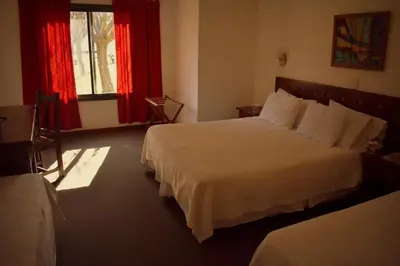 a bedroom with a large white bed with red curtains at Villa de Merlo All Inclusive & Spa by MH in Merlo
