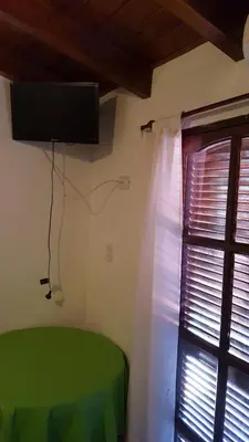 a bedroom with a green bed and a window at La Herradura in Santa Rosa de Calamuchita