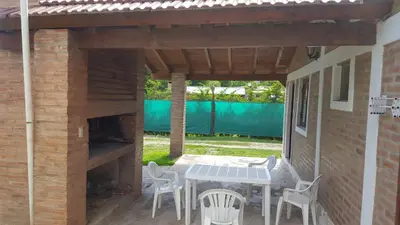 a patio with a table and chairs under a pergola at La Herradura in Santa Rosa de Calamuchita