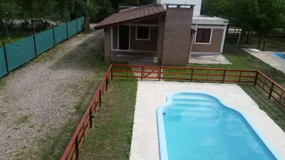 a swimming pool in a yard with a fence at La Herradura in Santa Rosa de Calamuchita