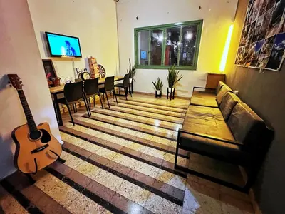 a living room with a guitar and a couch at Lacandona Hostel in Cordoba