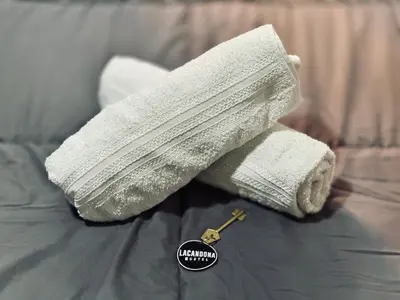 a pair of white towels with a key on a bed at Lacandona Hostel in Cordoba