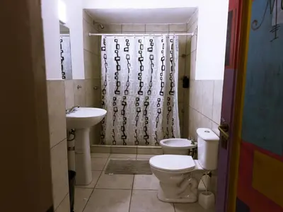 a bathroom with two toilets and a shower curtain at Lacandona Hostel in Cordoba