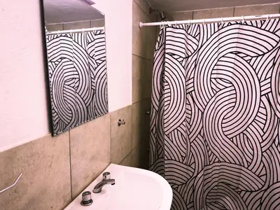 a bathroom with a sink and a shower curtain at Lacandona Hostel in Cordoba