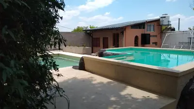 a swimming pool in the backyard of a house at Cabañas El Descanso in Villa Carlos Paz