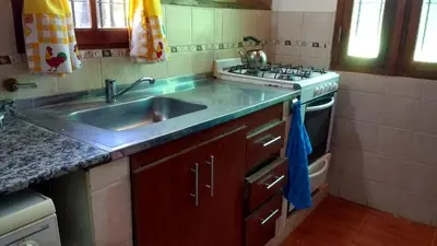 a kitchen with a sink and a stove at Cabañas El Descanso in Villa Carlos Paz