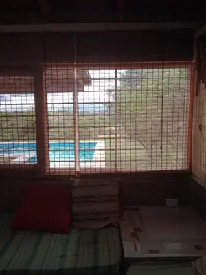 a room with a window with a view of a pool at Cabaña El Mirador de Bialet Masse in Villa Parque Siquiman