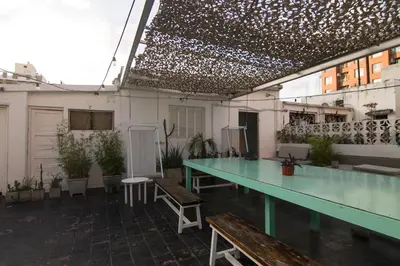a patio with a table and benches in a building at Aldea Hostel & Café in Cordoba