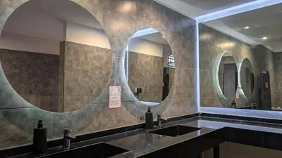 a bathroom with two sinks and two mirrors at Aldea Hostel & Café in Cordoba