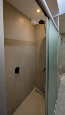 a bathroom with a shower with a glass door at Aldea Hostel & Café in Cordoba