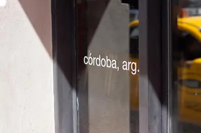 a sticker on a glass door with the words cordosaccoagencyagency at Aldea Hostel & Café in Cordoba