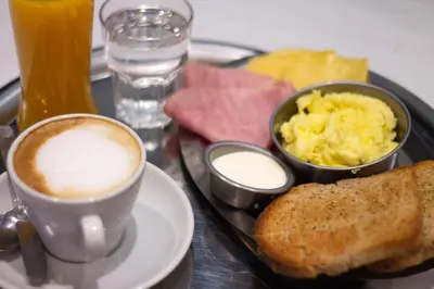 a breakfast tray with a cup of coffee and eggs and toast at Aldea Hostel & Café in Cordoba
