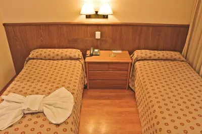 a hotel room with two beds with a bow tie on them at Hotel Felipe II in Cordoba