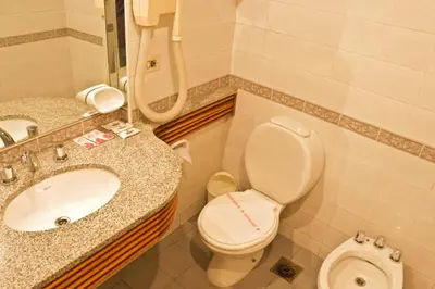 a bathroom with a toilet and a sink at Hotel Felipe II in Cordoba