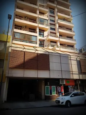 a white car parked in front of a tall building at El Abrojal - Departamento con Estacionamiento , zona Patio Olmos in Cordoba