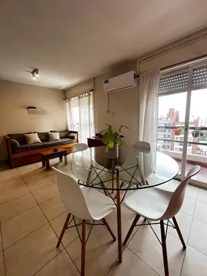 a dining room with a glass table and white chairs at El Abrojal - Departamento con Estacionamiento , zona Patio Olmos in Cordoba