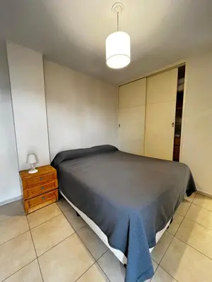 a bedroom with a bed with a blue blanket on it at El Abrojal - Departamento con Estacionamiento , zona Patio Olmos in Cordoba