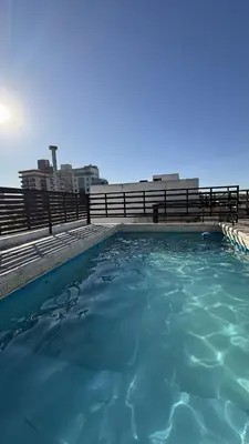 a swimming pool with blue water in front of a fence at Serena in Villa Carlos Paz