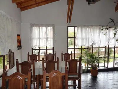 a room with a bed and windows with curtains at Hostería Lida in Merlo