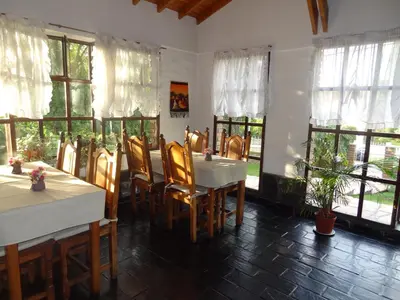 a dining room with tables and chairs and windows at Hostería Lida in Merlo