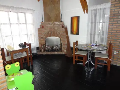 a living room with a table and a brick fireplace at Hostería Lida in Merlo