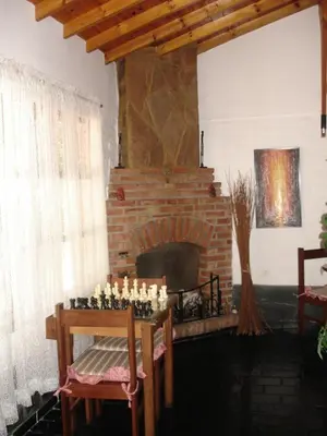 a living room with a fireplace and a table and chairs at Hostería Lida in Merlo