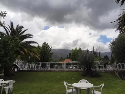 a patio with white tables and chairs in a yard at Hostería Lida in Merlo
