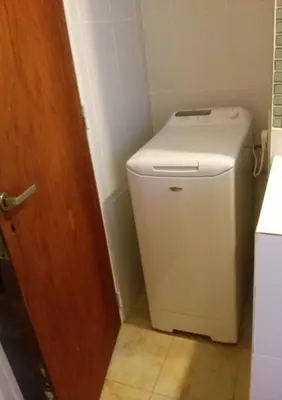 a small white toilet in a bathroom with a door at Espacio C Av Marcelo t de Alvear Vista Centro in Cordoba