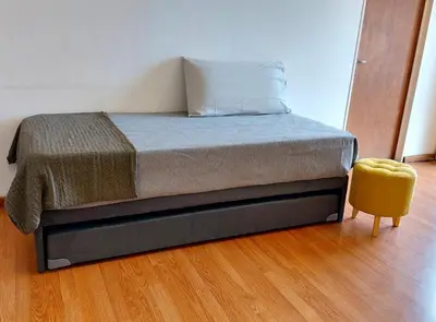 a bedroom with a bed and a yellow stool at Espacio C Av Marcelo t de Alvear Vista Centro in Cordoba