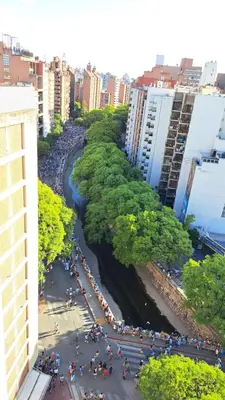 a group of people walking along a river in a city at Espacio C Av Marcelo t de Alvear Vista Centro in Cordoba