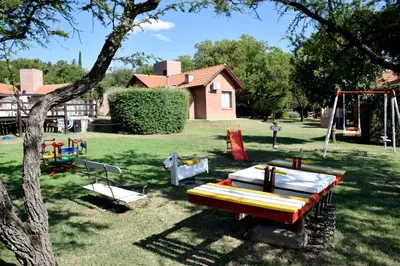 a yard with a park with swings and a playground at Cabañas Babin Kuk in Merlo