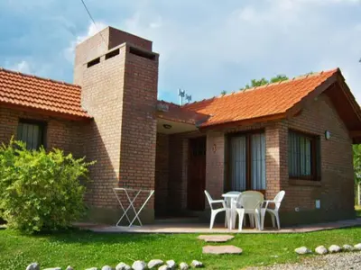 a brick house with a table and chairs in the yard at Cabañas Babin Kuk in Merlo
