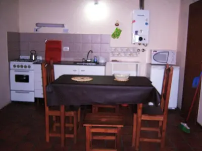 a kitchen with a table with chairs and a sink at Cabañas Babin Kuk in Merlo