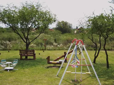 a playground with a slide and chairs in a park at Cabañas Babin Kuk in Merlo