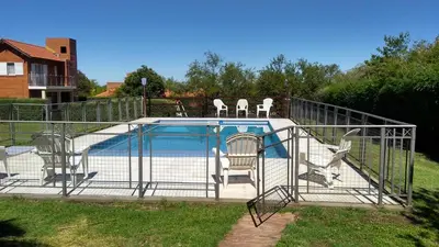 a bird cage with chairs and a swimming pool at Cabañas Babin Kuk in Merlo