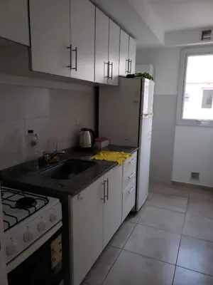 a kitchen with white cabinets and a sink and a refrigerator at Colón in Cordoba