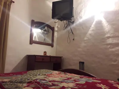 a bedroom with a bed and a tv on a wall at Departamentos Carlos Paz bajada al lago in Villa Carlos Paz
