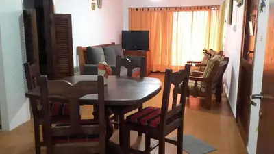 a living room with a wooden table and chairs at Departamentos Carlos Paz bajada al lago in Villa Carlos Paz