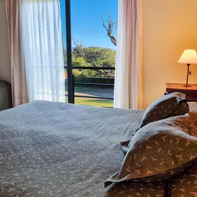 a bedroom with a bed and a large window at Posada La Soñada in Villa General Belgrano