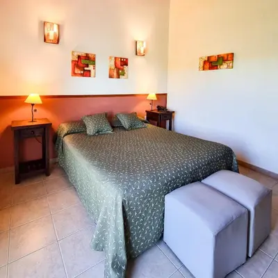 a bedroom with a bed and two tables and two lamps at Posada La Soñada in Villa General Belgrano