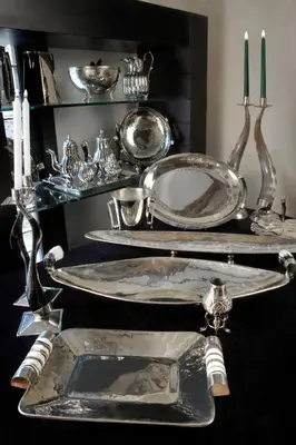 a table with silver plates and candles on it at Altos de Belgrano Hotel Cabañas Golf y Spa in Villa General Belgrano