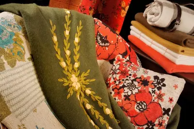 a book with a flower on it next to other fabrics at Altos de Belgrano Hotel Cabañas Golf y Spa in Villa General Belgrano
