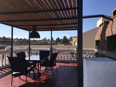 a patio with a table and chairs on a balcony at Atenea in Villa Carlos Paz