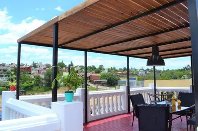 a pergola on a deck with a view of a city at Atenea in Villa Carlos Paz